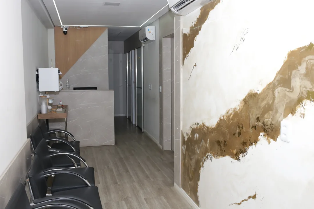 Recepção real do COI Fortaleza, com balcão de pedra e corredor de acesso aos consultórios
