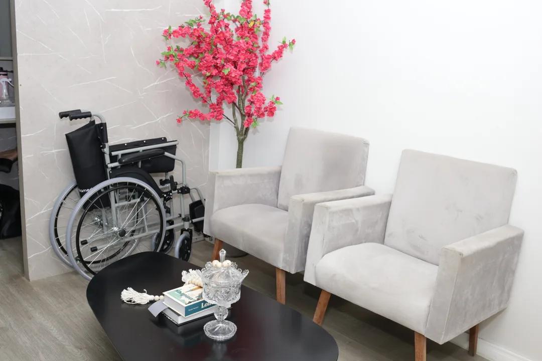 Sala de espera do COI com poltronas claras, mesa e flores